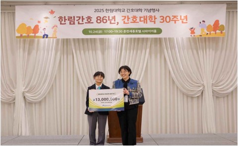 2025 한림대학교 간호대학 기념행사 / 한림간호 86년, 간호대학 30주년 / 10월 24일 금요일 오후 5시부터 오후 7시 30분 춘천세종호텔 사파이어홀이라는 내용이 적힌 현수막 아래에 2명의 사람(교수님)이 한림대학교 간호대학 발전기금 금 일천삼백만원 간호대학 1999년 졸업생 일동 한림대학교 간호대학 이라는 내용이 적힌 팻말을 들고 서있는 사진이다.